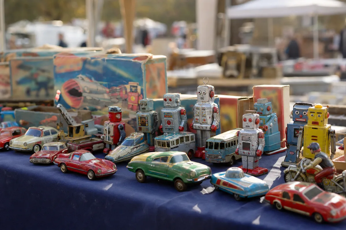 Étal de brocante couvert de jouets anciens en tôle et de boîtes vintage