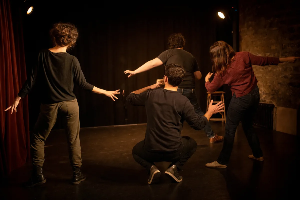 Adultes en atelier d’improvisation théâtrale sur une petite scène