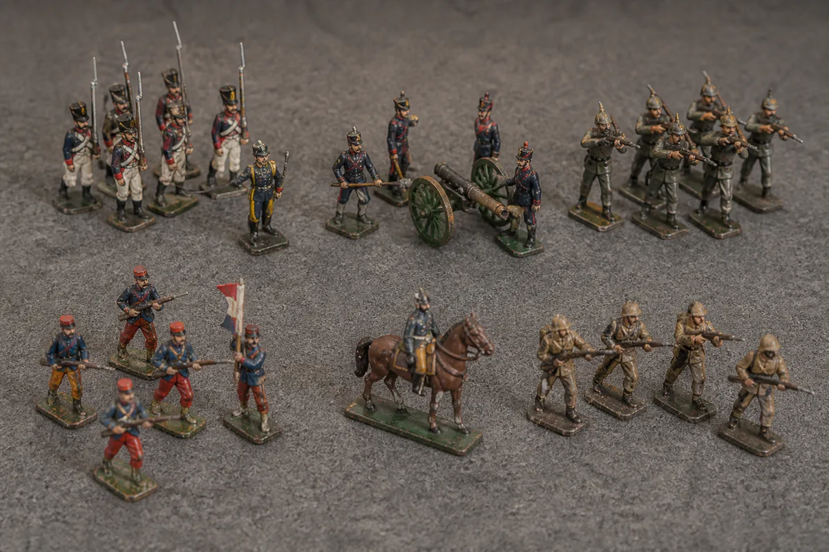Figurines militaires miniatures triées par famille sur un plateau de feutrine grise